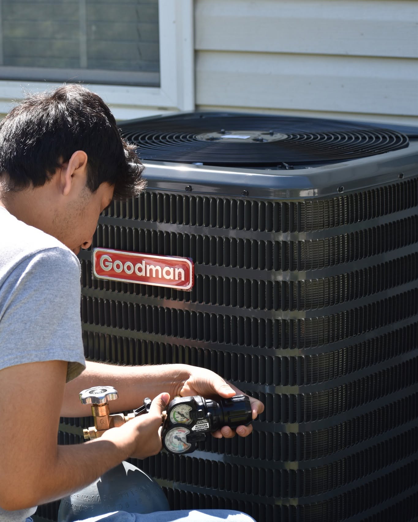 Technician charging refrigerant on a residential condenser unit