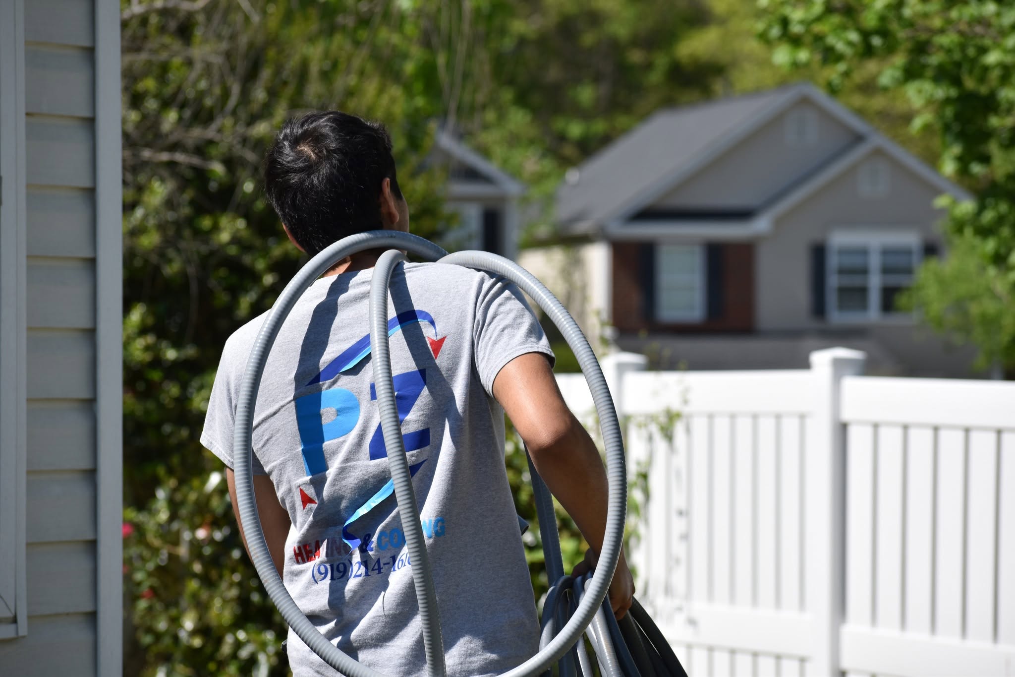 PZ technician carrying flexible ductwork to a job site
